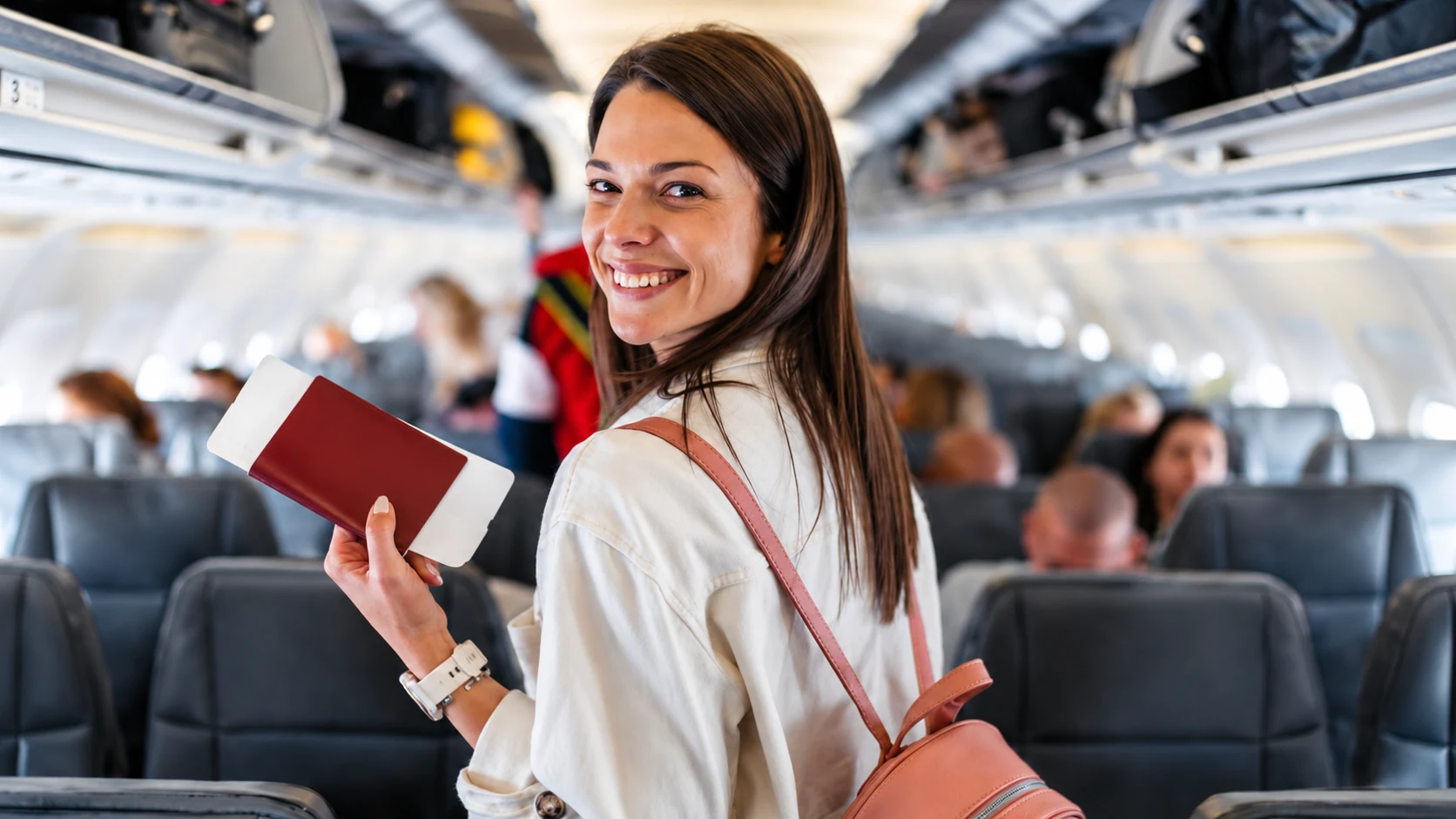 Passageira sorri durante o embarque em um avião.